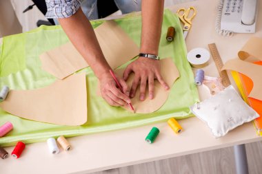 Atölyesinde çalışan yakışıklı bir terzi.