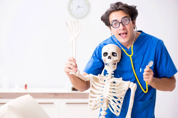 Смешной доктор со скелетом в больнице — стоковое фото