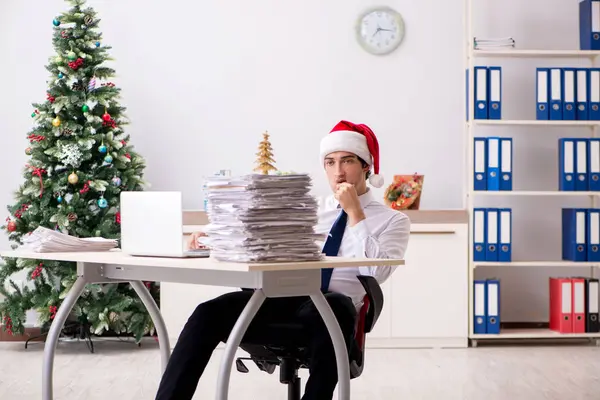 Mladý pracovník pracující v úřadu na vánoční směny — Stock fotografie