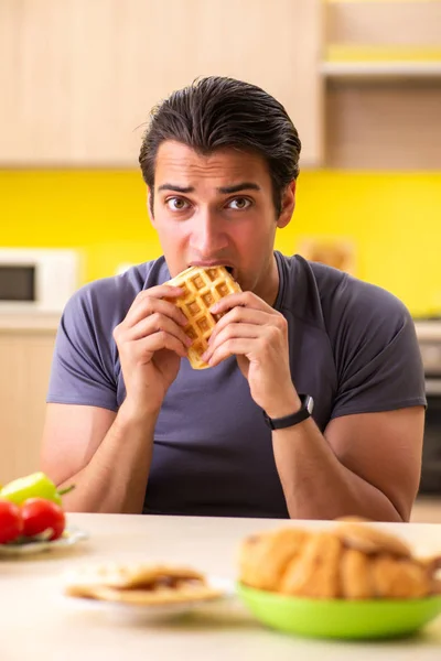 Hombre que tiene difícil elección entre la comida sana y no saludable —  Fotos de Stock