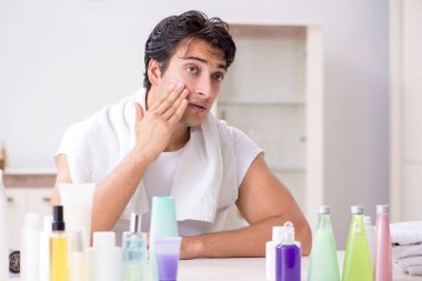 Tuvaletteki genç yakışıklı adam hijyen konseptinde. 