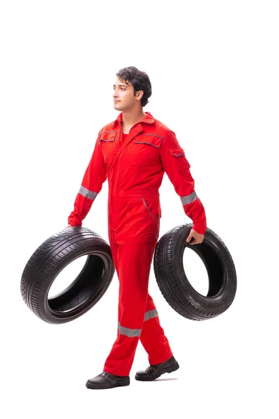 Mladý garážový pracovník s pneumatikou izolovanou na bílém — Stock fotografie