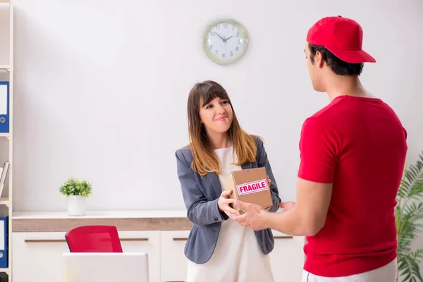 Courier delivering parcel to the office — Stock Photo, Image