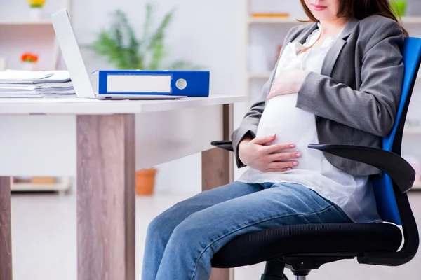 Pregnant woman struggling with pain in office — Stock Photo, Image