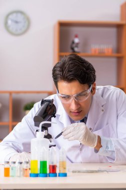 Genç yakışıklı biyokimyacı laboratuvarda çalışıyor.  