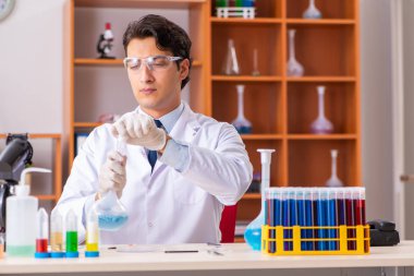 Genç yakışıklı biyokimyacı laboratuvarda çalışıyor. 