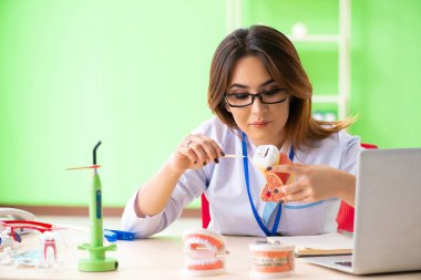 Diş implantı üzerinde çalışan kadın dişçi.