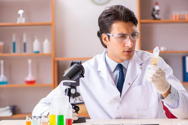 Joven bioquímico guapo trabajando en el laboratorio — Foto de Stock