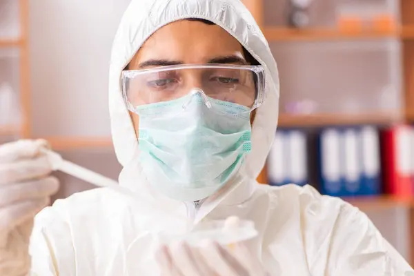 Joven bioquímico con traje protector trabajando en el laboratorio —  Fotos de Stock