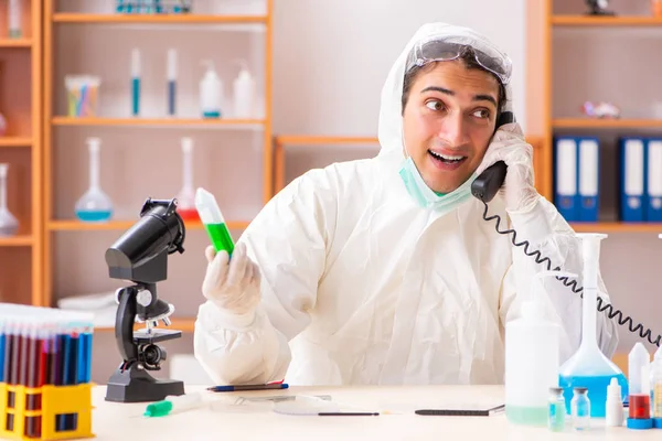 Junge Biochemikerin im Schutzanzug bei der Arbeit im Labor — Stockfoto
