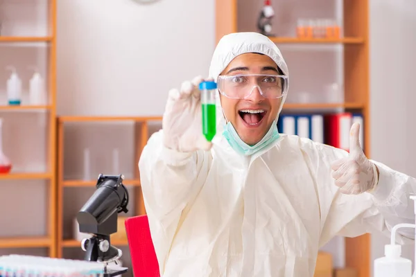 Jonge biochemicus in een beschermend pak in het lab — Stockfoto