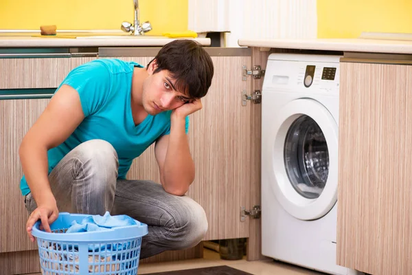 Молодий чоловік робить прання вдома — стокове фото
