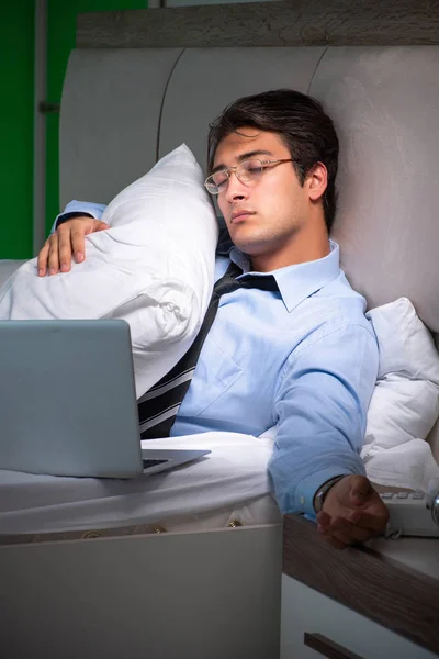 Молодой бизнесмен в состоянии стресса в спальне ночью — стоковое фото