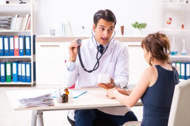 Genç doktor, kadınların tansiyonunu ölçüyor.