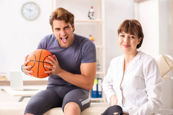 Handsome basketball player visiting female doctor traumatologist — Stock Photo, Image