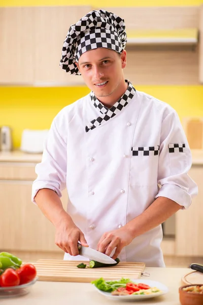 Joven cocinero profesional preparando ensalada en la cocina —  Fotos de Stock