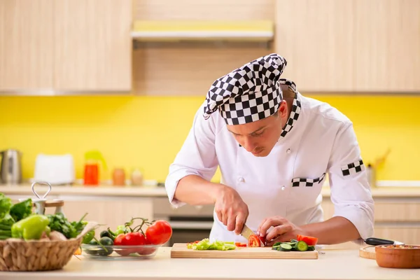 Jovem cozinheiro profissional preparando salada na cozinha — Fotografia de Stock