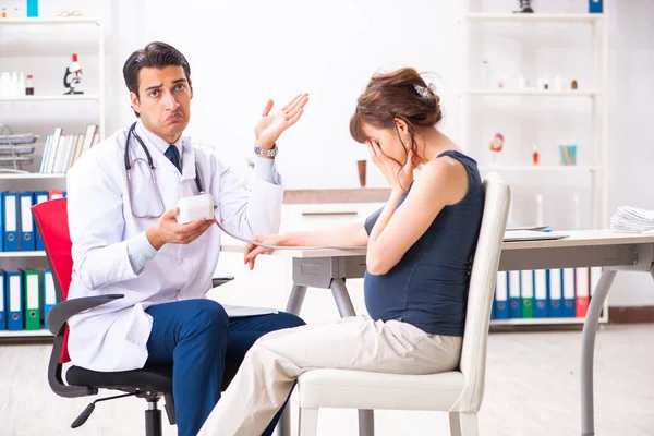 Young doctor checking pregnant womans blood pressure — Stock Photo, Image