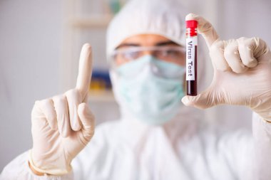 Genç yakışıklı laboratuvar asistanı hastanede kan örnekleri test ediyor. 