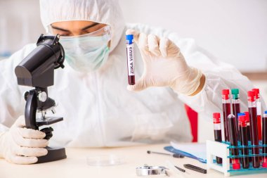 Genç yakışıklı laboratuvar asistanı hastanede kan örnekleri test ediyor. 