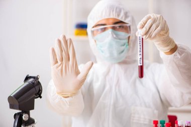Genç yakışıklı laboratuvar asistanı hastanede kan örnekleri test ediyor. 