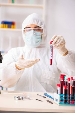 Genç yakışıklı laboratuvar asistanı hastanede kan örnekleri test ediyor. 