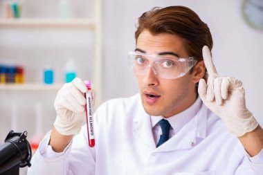 Genç yakışıklı laboratuvar asistanı hastanede kan örnekleri test ediyor. 