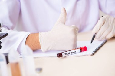 Genç yakışıklı laboratuvar asistanı hastanede kan örnekleri test ediyor. 
