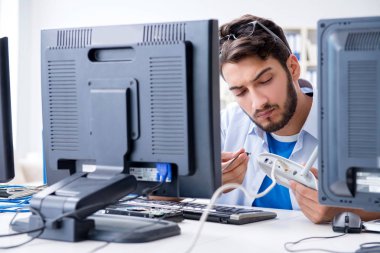 IT teknisyeni bilişim ekipmanlarına bakıyor.