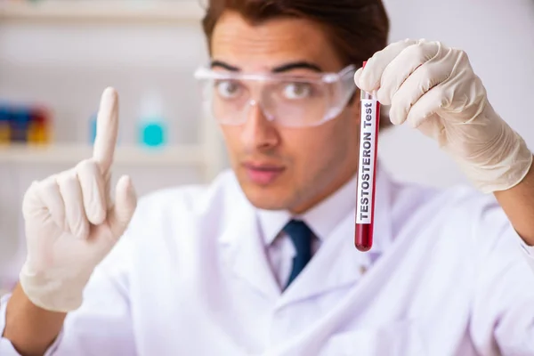 Młody przystojny asystent laboratoryjny badający próbki krwi w szpitalu — Zdjęcie stockowe
