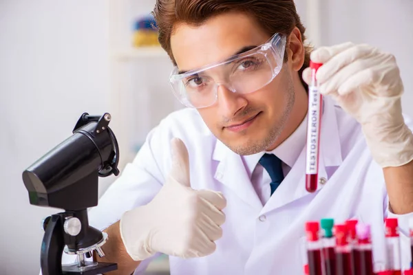 Jovem assistente de laboratório bonito testando amostras de sangue no hospital — Fotografia de Stock