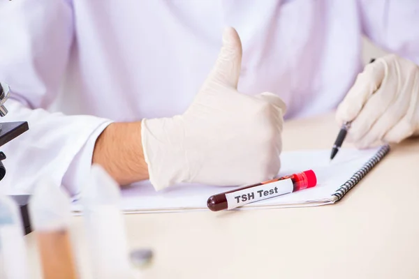 Asistente de laboratorio joven guapo analizando muestras de sangre en el hospital — Foto de Stock