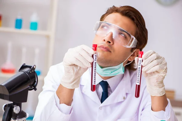 Jovem assistente de laboratório bonito testando amostras de sangue no hospital — Fotografia de Stock