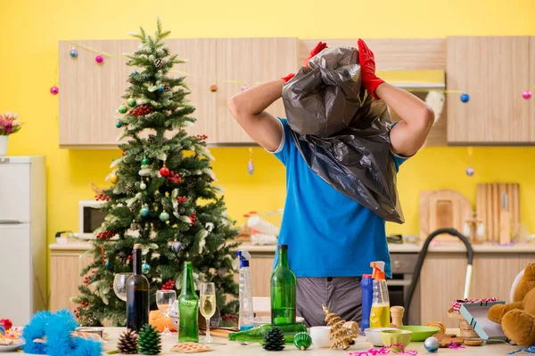 Giovane uomo pulizia cucina dopo la festa di Natale — Foto Stock