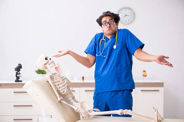 Funny doctor with skeleton in hospital — Stock Photo, Image