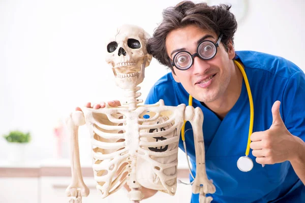 Funny doctor with skeleton in hospital — Stock Photo, Image