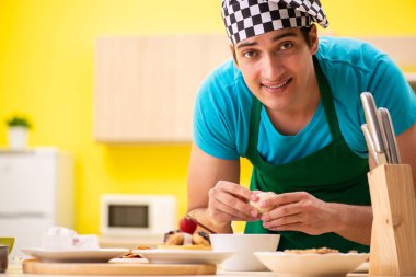 Adam evde pasta hazırlıyor.