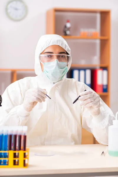 Joven bioquímico con traje protector trabajando en el laboratorio — Foto de Stock