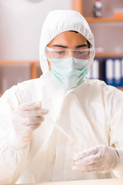 Junge Biochemikerin im Schutzanzug bei der Arbeit im Labor — Stockfoto