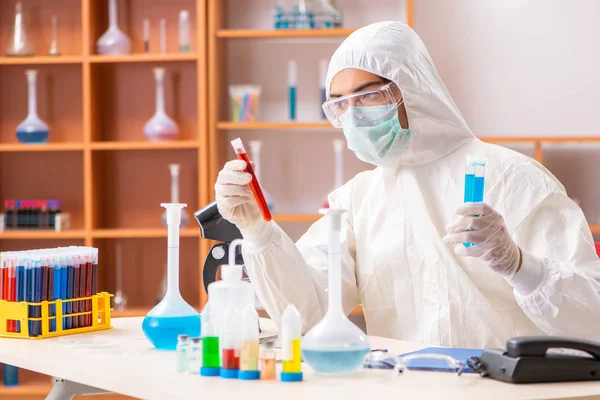 Young biochemist wearing protective suit working in the lab — Stock Photo, Image