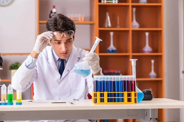 Молодой красивый биохимик, работающий в лаборатории — стоковое фото