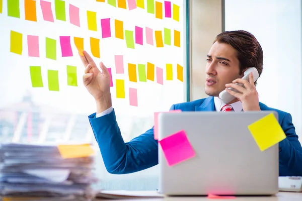 Joven empleado guapo con muchas prioridades contradictorias — Foto de Stock