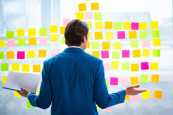 Young handsome employee with many conflicting priorities   