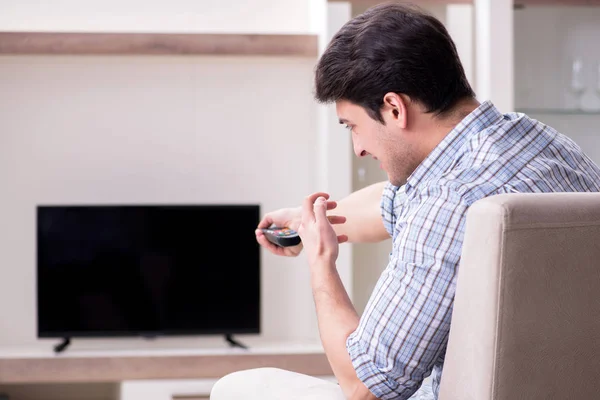 Młody człowiek ogląda telewizję w domu — Zdjęcie stockowe