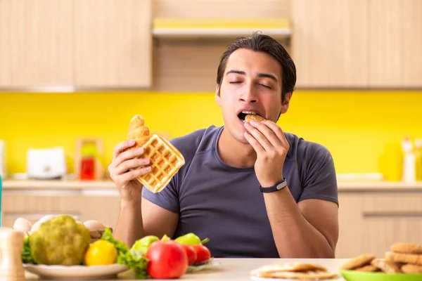 Hombre que tiene difícil elección entre la comida sana y no saludable —  Fotos de Stock