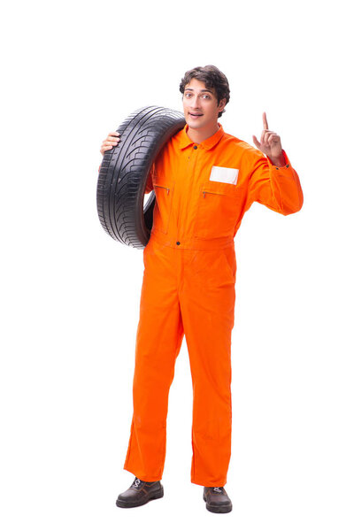 Young garage worker with tyre isolated on white