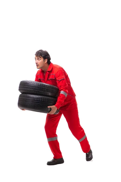 Joven trabajador de garaje con neumático aislado en blanco — Foto de Stock