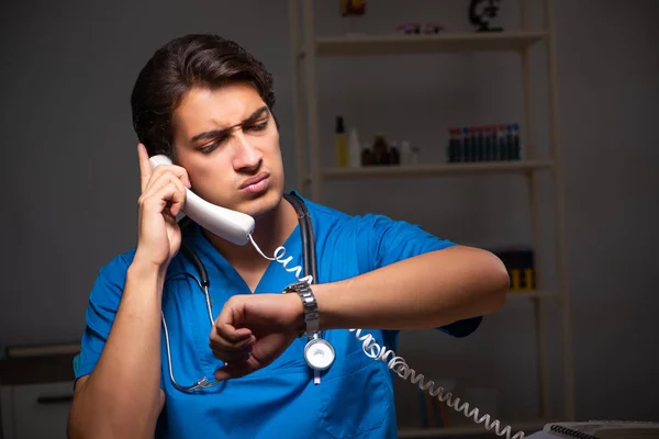 Jonge knappe dokter in nachtdienst in het ziekenhuis — Stockfoto