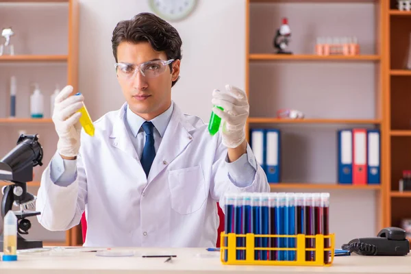 Jovem bioquímico bonito que trabalha no laboratório — Fotografia de Stock