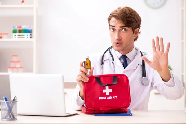 Jovem médico com kit de primeiros socorros no hospital — Fotografia de Stock